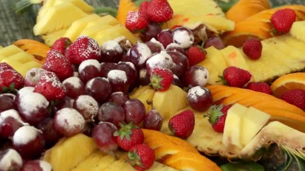 Sortiment an frischen Früchten. Erdbeere, Ananas, Trauben, Puderzucker. - Filmmaterial, Video