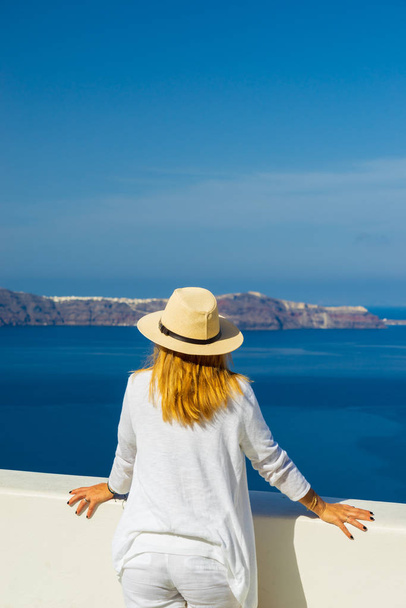 Luxury travel vacation woman looking at view on Santorini island in Greece. Amazing view of sea and Caldera. - Fotoğraf, Görsel