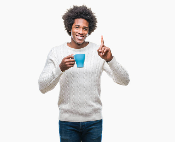 Afroamerikanischer Mann trinkt Tasse Kaffee über isoliertem Hintergrund überrascht mit einer Idee oder Frage Zeigefinger mit glücklichem Gesicht, Nummer eins - Foto, Bild