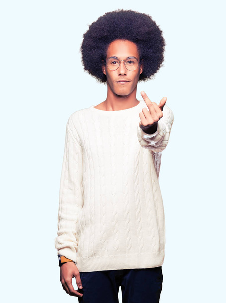 Young african american man with afro hair wearing glasses Showing middle finger, impolite and rude fuck off expression - Фото, зображення