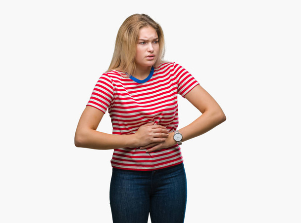 Young caucasian woman over isolated background with hand on stomach because nausea, painful disease feeling unwell. Ache concept. - Foto, imagen