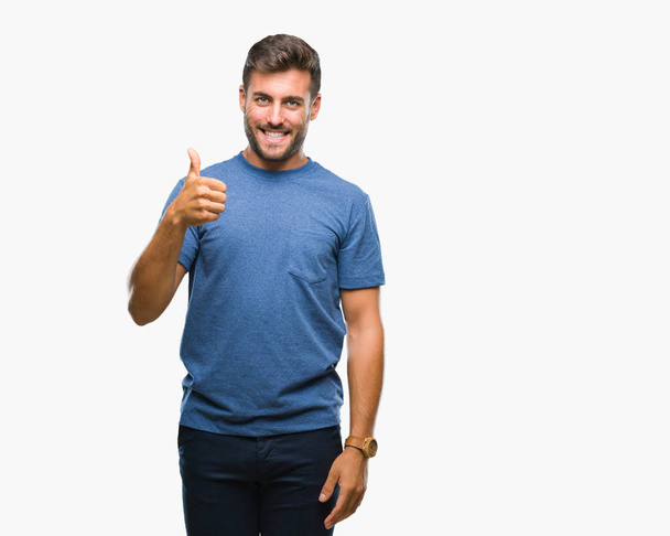 Mladý pohledný muž izolované pozadí dělá šťastné palec nahoru gesto rukou. Schvalování výraz s ukazuje úspěch při pohledu na fotoaparát. - Fotografie, Obrázek