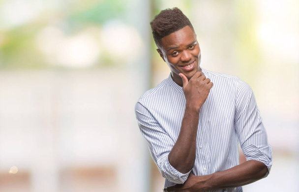 Young african american man over isolated background looking confident at the camera with smile with crossed arms and hand raised on chin. Thinking positive. - Photo, Image