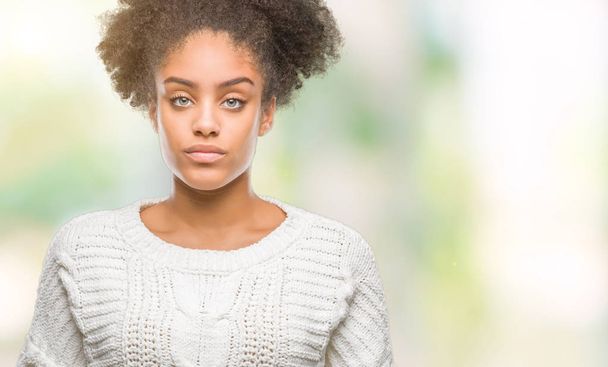 Giovane donna afro-americana che indossa maglione invernale su sfondo isolato con grave espressione sul viso. Semplice e naturale guardando la fotocamera
. - Foto, immagini