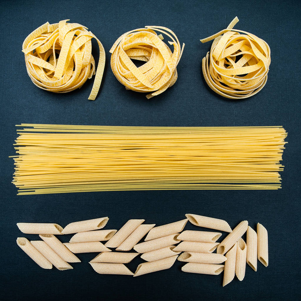 Pâtes sèches de différents types sur fond noir, concept élégant, spaghetti, tagliatelle, Penne, Flat lay
 - Photo, image