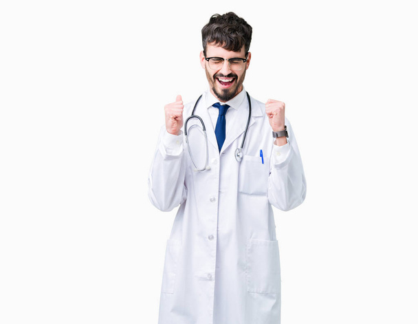 Zafer kutluyor gülümseyen izole arka kolları olan başarı için heyecan üzerinde hastane ceket giyen genç doktor adam kaldırdı. Kazanan kavramı. - Fotoğraf, Görsel