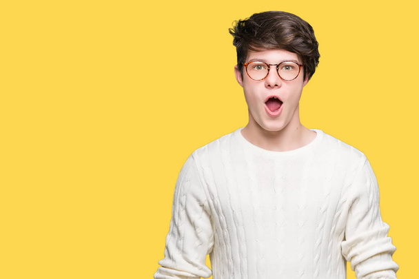 Young handsome man wearing glasses over isolated background afraid and shocked with surprise expression, fear and excited face. - Photo, Image