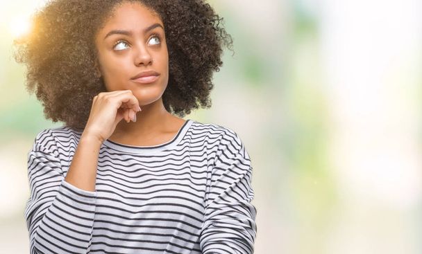 Mladá žena afro americký izolované pozadí s rukou na bradě přemýšlet o otázce, zamyšlený výraz. Usmívající se zamyšlenou tváři. Pochybnost koncept. - Fotografie, Obrázek