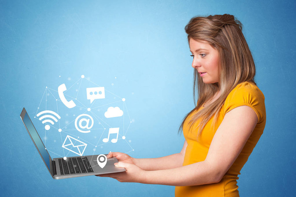 Woman holding laptop with online symbols - Foto, Imagem