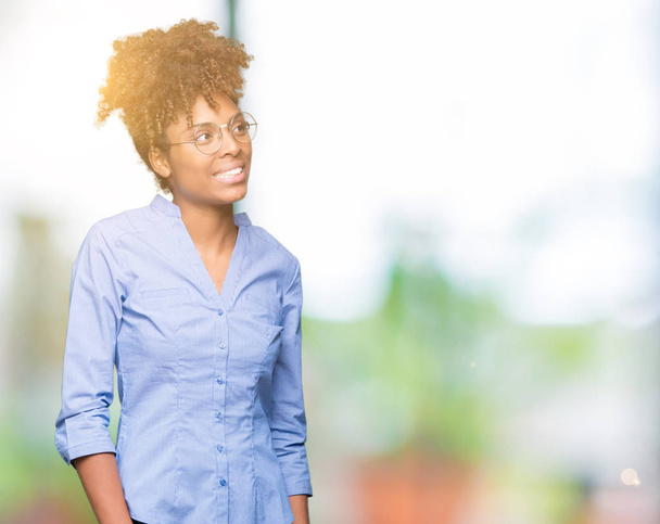 Beautiful young african american business woman over isolated background looking away to side with smile on face, natural expression. Laughing confident. - Photo, image