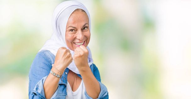 Moyen-âge arabe arabe femme portant hijab arabe sur fond isolé Prêt à se battre avec geste de défense poing, visage en colère et bouleversé, peur du problème
 - Photo, image