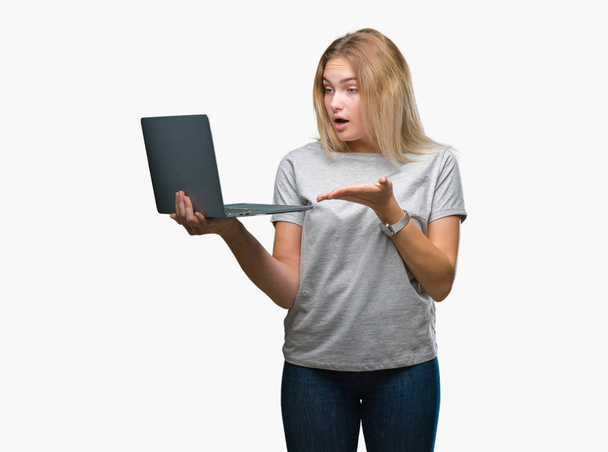Joven mujer caucásica usando computadora portátil sobre fondo aislado muy feliz señalando con la mano y el dedo
 - Foto, imagen