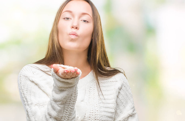 Young beautiful caucasian woman wearing winter sweater over isolated background looking at the camera blowing a kiss with hand on air being lovely and sexy. Love expression. - Photo, Image