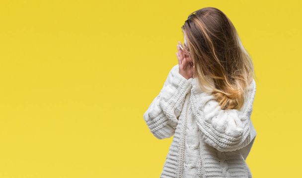 Jonge mooie blonde vrouw winter trui en zonnebril dragen over geïsoleerde achtergrond met trieste uitdrukking waarin gezicht met handen terwijl het huilen. Depressie concept. - Foto, afbeelding
