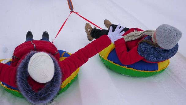 kırmızı ceket ile yolculuk kar kış bir şişme karda çocuklarda boru ve süper kahramanlar oyun. mutlu kız kış parkta Noel tatili için rahatlatıcı. Ağır çekim - Fotoğraf, Görsel