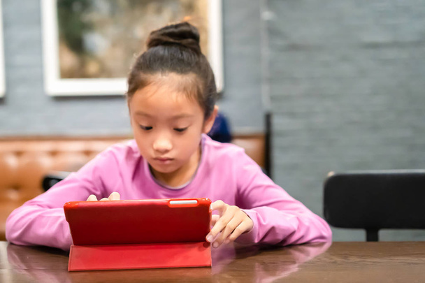 Девочка смотрит компьютерный планшет в комнате
 - Фото, изображение