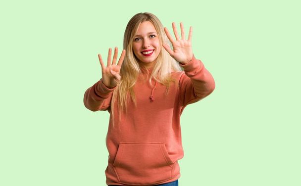 Nuori tyttö laskee yhdeksän sormet vihreällä taustalla
 - Valokuva, kuva