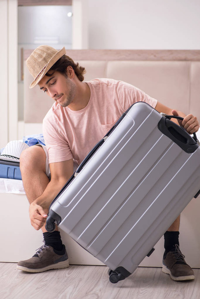 Man met koffer in slaapkamer wachten op reis  - Foto, afbeelding