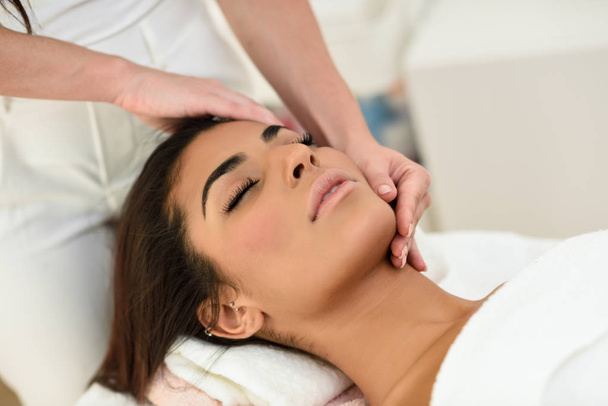 Femme arabe recevant un massage de la tête dans un centre de bien-être spa. Beauté et concepts esthétiques
. - Photo, image