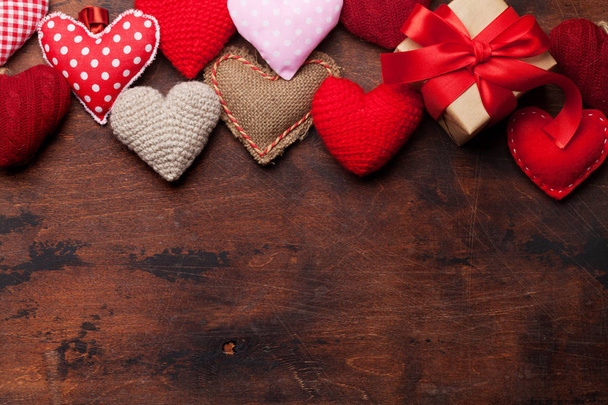 Tarjeta de felicitación del día de San Valentín con juguetes de corazón hechos a mano y caja de regalo de amor sobre fondo de madera. Vista superior con espacio para sus saludos. Puesta plana
 - Foto, Imagen