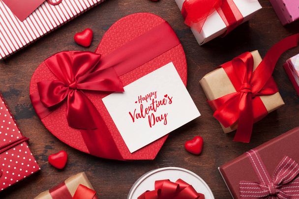 Valentinstag-Grußkarte mit Herz-Geschenkschachteln auf Holzgrund. Ansicht von oben mit Platz für Ihre Grüße. flache Lage - Foto, Bild