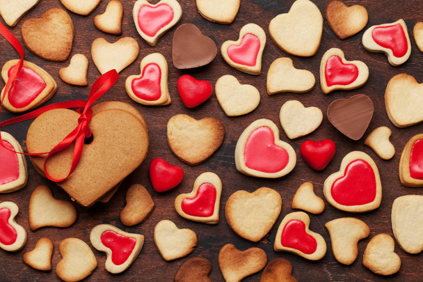 Sevgililer günü tebrik kartı ile kalp şeklinde kurabiye ve tatlılar ahşap arka plan üzerinde. Üstten görünüm. Düz yatıyordu - Fotoğraf, Görsel