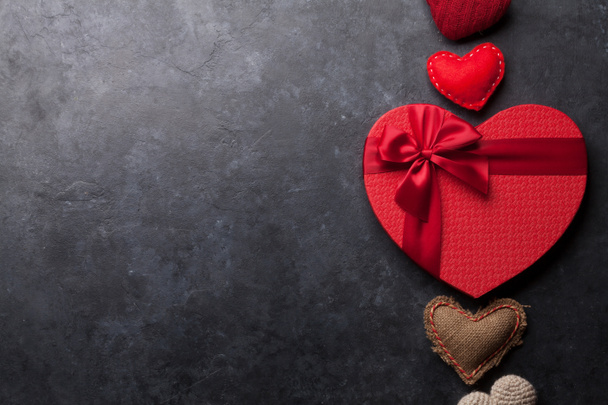 Biglietto di auguri per San Valentino con giocattoli cuore fatti a mano e scatola regalo d'amore su sfondo di pietra. Vista dall'alto con spazio per i vostri saluti. Posa piatta
 - Foto, immagini