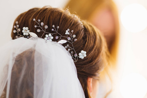 крупным планом прическа невесты и свадебная вуаль. в украшениях для волос с бусинами
 - Фото, изображение