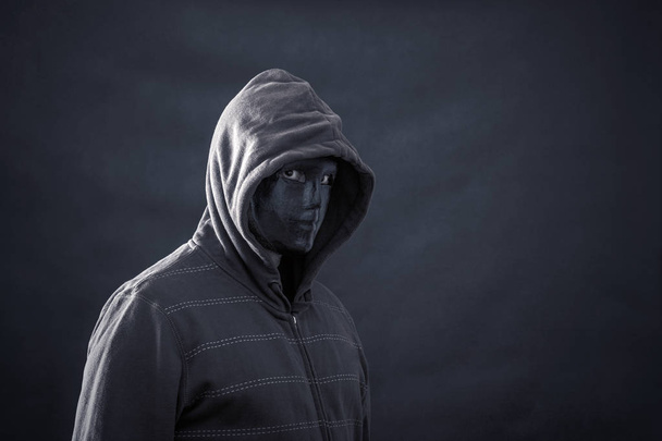 Hooded man with black mask in the dark  - Photo, Image