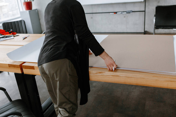 Female hands are drawing on a large wooden table in the loft style in the office - Foto, Bild