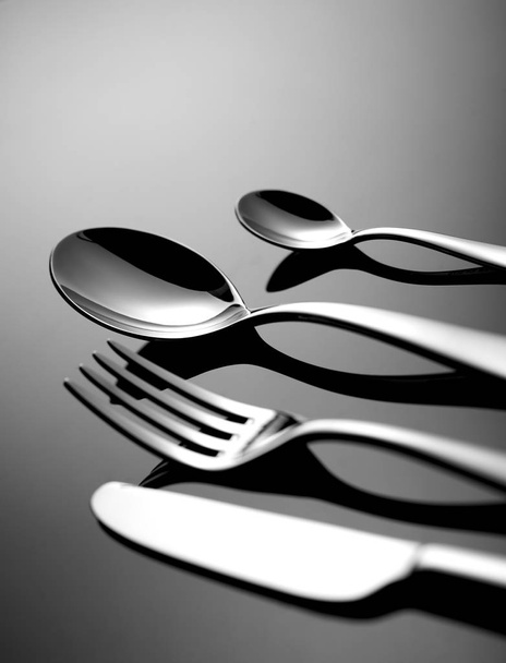 Cucchiaio, coltello e forchetta su nero
 - Foto, immagini