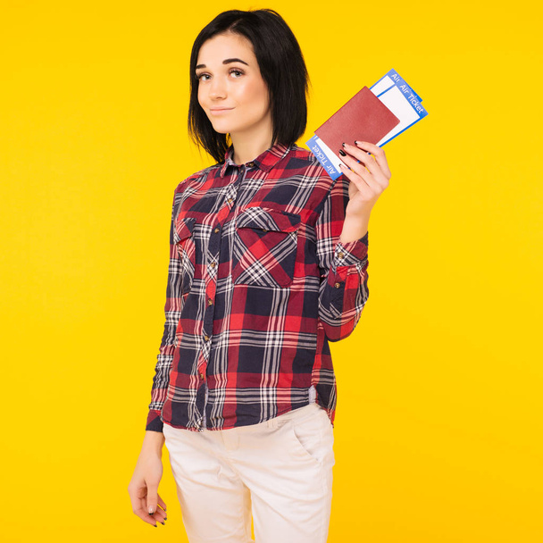 Joven estudiante emocionada sonriente sosteniendo pasaporte billete de embarque aislado en el fondo amarillo. Educación en la universidad en el extranjero. Vuelo aéreo - Imagen
 - Foto, Imagen
