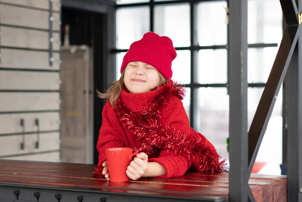 niña sentada en un café en Navidad
 - Foto, imagen