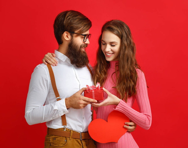 concept de Saint Valentin. heureux jeune couple avec coeur, fleurs, cadeau sur fond rouge
 - Photo, image