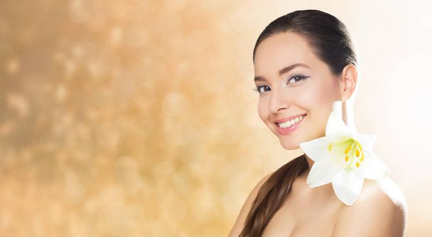 Portrait of brunette beauty in light makeup with white flower. - Foto, Imagen