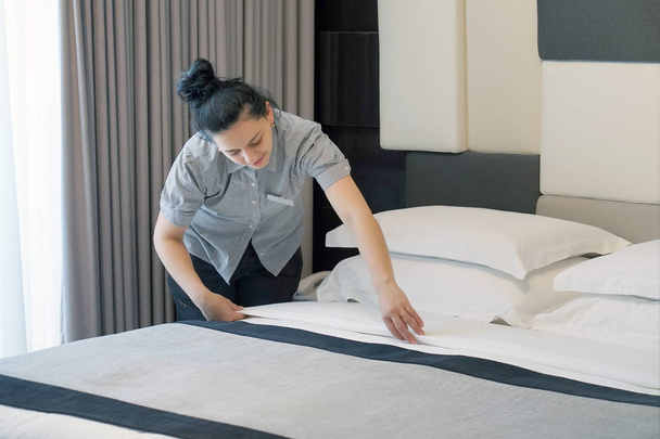 Maid making bed in hotel room. Housekeeper Making Bed - Foto, Imagem