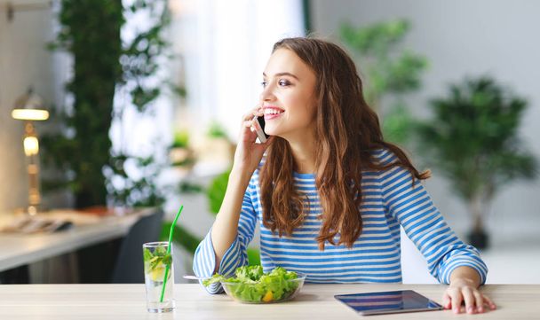 здоровое питание. счастливая молодая девушка ест салат с планшетным компьютером по утрам на кухне
 - Фото, изображение