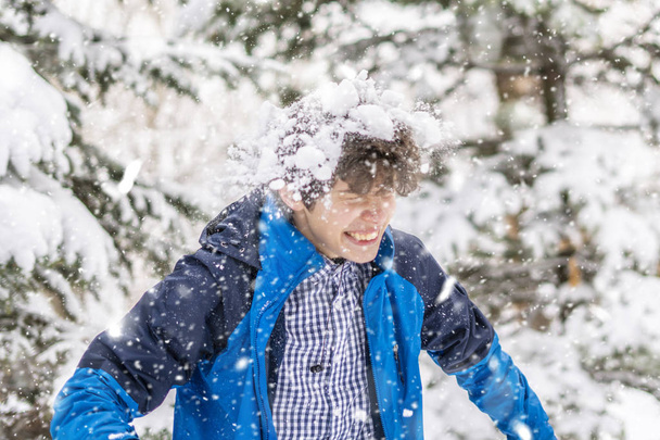 heureux adolescent guy appréciant chute de neige dans l 'hiver forêt enneigée f
 - Photo, image