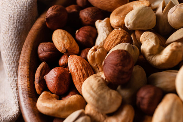 Assortment of nuts in wooden bowl on dark wooden table. - Foto, immagini