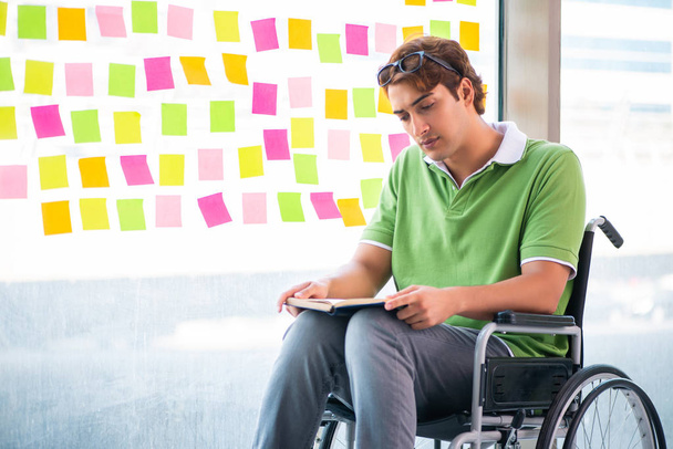 Νεαρός φοιτητής σε αναπηρική καρέκλα με πολλές αντικρουόμενες προτεραιότητες  - Φωτογραφία, εικόνα