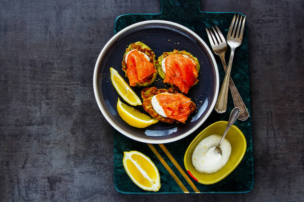 Flat lay of homemade zucchini fritters with smoked salmon and creme frache  - Valokuva, kuva