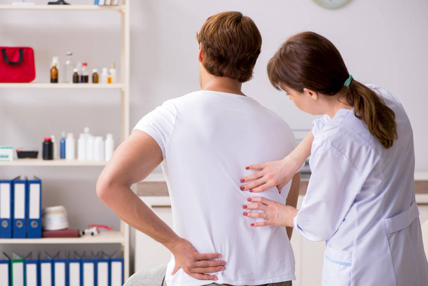 Male patient visiting young female doctor chiropractor  - Foto, Imagem