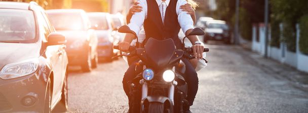Pareja joven montando una motocicleta moderna al atardecer
 - Foto, Imagen