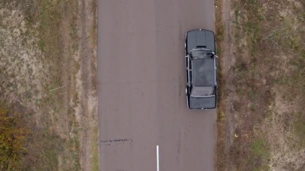 Luftaufnahmen eines Autos auf einer Landstraße. Luftaufnahme eines schwarzen BMW auf Landstraße - Filmmaterial, Video
