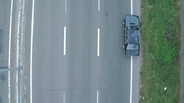 Luftaufnahmen von Auto, das auf der Autobahn ist. Luftaufnahme eines schwarzen BMW, der auf der Autobahn unterwegs ist - Filmmaterial, Video