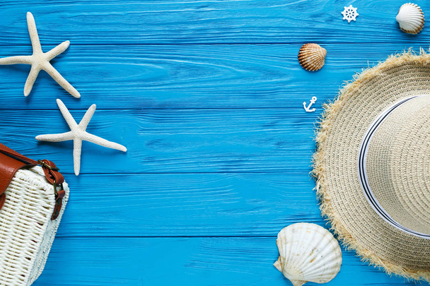 White rattan bag, straw hat on blue background. Bamboo trendy bag, starfish, shells. Summer fashion flat lay, vacation, travel concept. Top view with copy space.  - Fotoğraf, Görsel