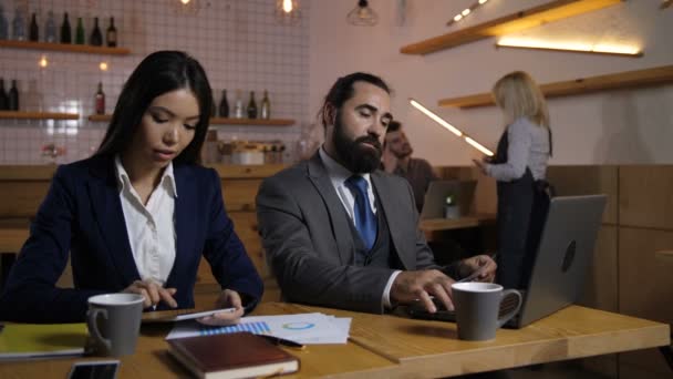 Бизнесмены, работающие над цифровыми устройствами в кафе
 - Кадры, видео