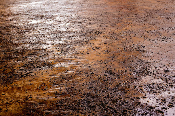 Muchos agujeros rugosos en el suelo de hormigón de color oxidado
 - Foto, Imagen
