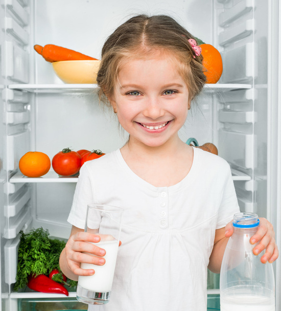 little girl against a refrigerator - Zdjęcie, obraz