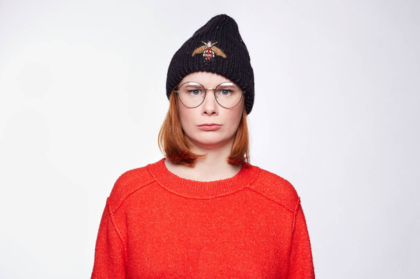 Portrait de jeune femme européenne à la peau rousse et propre, à la tête rouge, portant des vêtements d'hiver décontractés, regardant la caméra avec une expression sérieuse. attrayant caucasien élégant femme modèle posant à l'intérieur
. - Photo, image